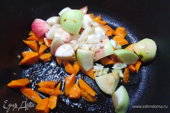 Добавьте нарезанные яблоки и рубленый чеснок. Жарьте, помешивая, 3–5 минут.