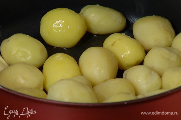 Разогреть в глубокой сковороде растительное и сливочное масло и слегка обжарить отваренный картофель.