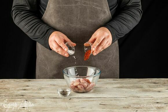 Куриные бедра нарежьте небольшими кусочками, посыпьте перцем, паприкой и солью.