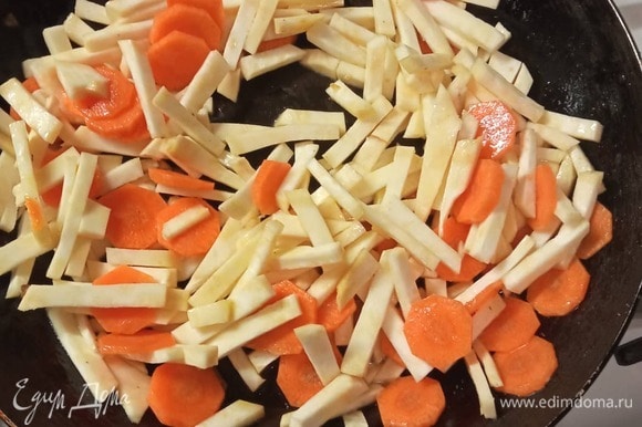 Нарезать морковь кружочками, а корень сельдерея — брусочками. Обжарить на другой сковороде в масле 3 минуты. Добавить нашинкованный зеленый лук.