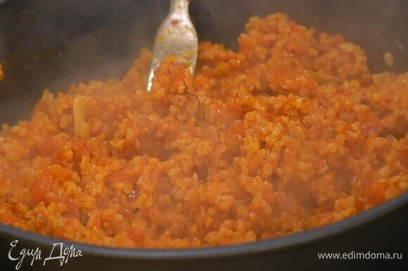 Добавить томатную пасту, помидоры в собственном соку, перемешать, влить горячий куриный бульон, накрыть крышкой и довести до готовности.