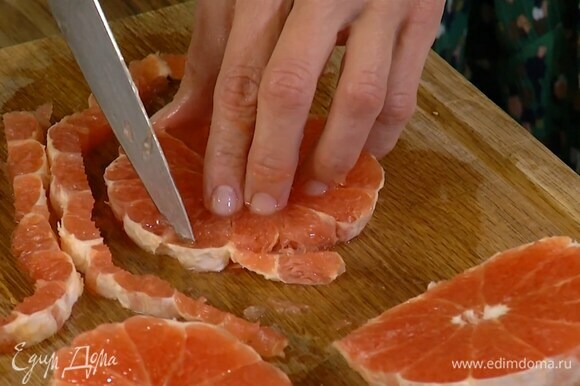 Грейпфрут очистить от кожуры и нарезать поперек на 6 кружков, затем обрезать края и разложить кружки в силиконовые формы для кексов.