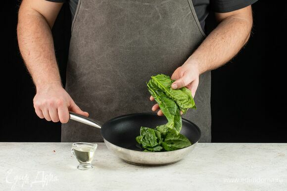 На сковороде разогрейте немного растительного масла. Промойте шпинат и положите на сковороду. Тушите 5 минут, помешивая, до уменьшения зелени в объеме.