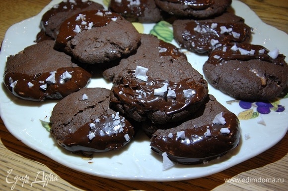 Покрыть половинку каждого печенья шоколадной глазурью и посыпать ее хлопьями морской соли.