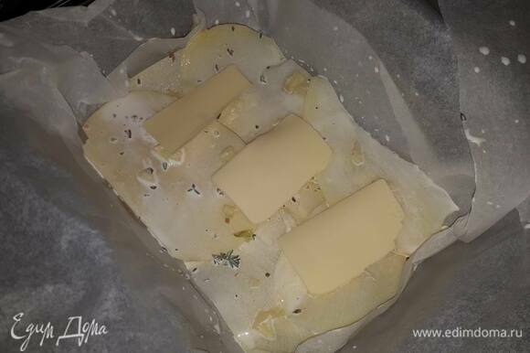 На дно формы для запекания выложите пекарскую бумагу (чтобы она закрывала бортики). Положите на дно 2–3 кубика масла. Окуните каждый кусочек картофеля в сливки и выложите на дно в 2–3 слоя. Посыпьте давленым чесноком, положите еще несколько кубиков масла и влейте 2–3 ст. л. сливок. Продолжите утрамбовывать картофель, чередуя с маслом и чесноком каждые 2–3 слоя картофеля.