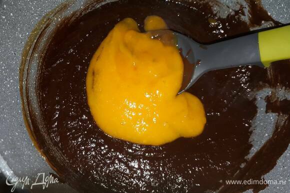 Влейте манговое пюре к шоколаду по частям, каждый раз размешивая до однородности.