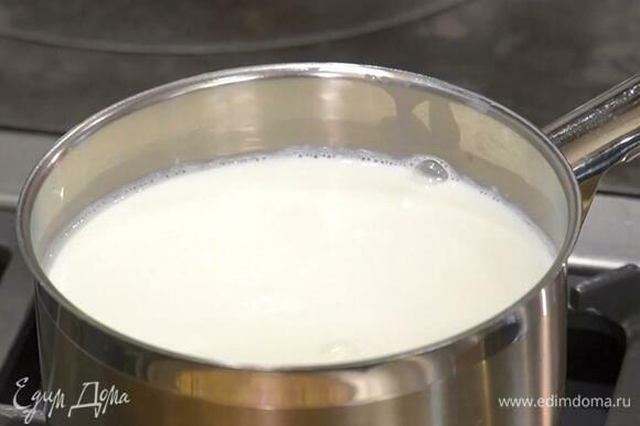 Молоко влить в кастрюлю и прогреть на небольшом огне до 40℃, затем всыпать закваску и все перемешать.