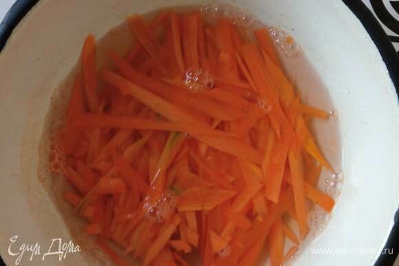 Морковь трем на терке для корейской моркови или режем тонкой соломкой. Заливаем морковь горячей подсоленной водой и даем постоять минут 10. Сливаем воду и обсушиваем морковь.