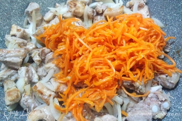 Добавить морковь по-корейски. Жарить 12–15 минут, помешивая.
