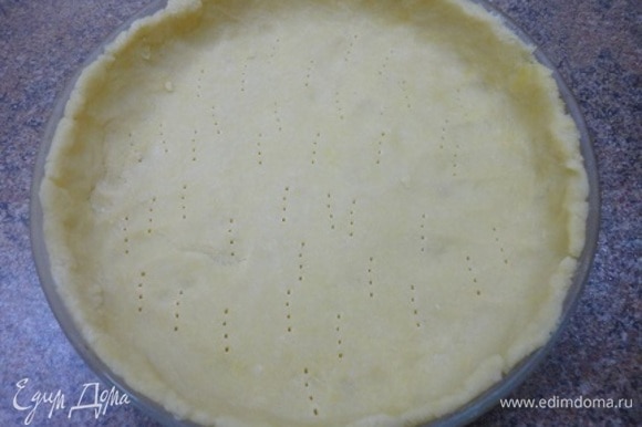 Включить духовку для разогрева до 180°C. Охлажденное тесто раскатать в круг и уложить в смазанную маслом форму диаметром 23–24 см. Наколоть вилкой и выпекать 15 минут при 180°C. Остудить.