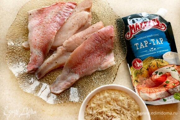 Филе рыбы слегка посолите, приправьте перцем, специями для рыбы. Отложите на 10–15 минут. За это время измельчите хлеб в крупную крошку, добавьте тертый пармезан и перемешайте.