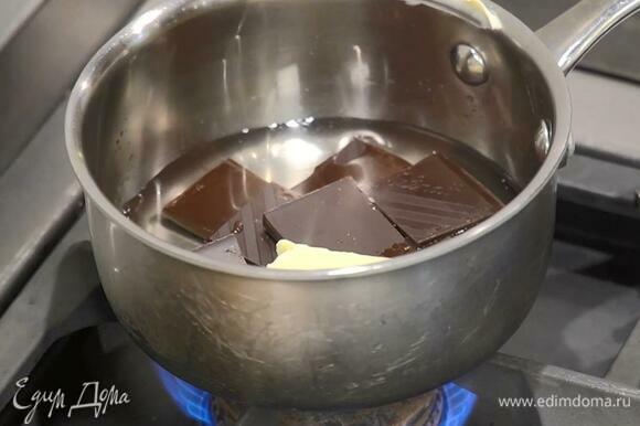 Шоколад поломать кусочками, выложить в ковшик, добавить 50 г сливочного масла, влить 120 мл кипяченой воды и растопить на медленном огне.