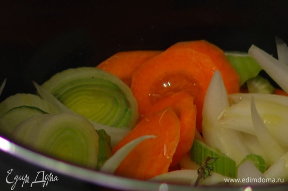 В чашу мультиварки влить половину растительного масла, выложить порей, сельдерей, лук, морковь и готовить на программе «жарка».
