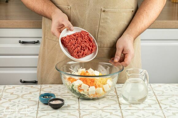 Смешайте овощи с сыром, зеленью и фаршем, приправьте начинку солью и перцем. Влейте воду.