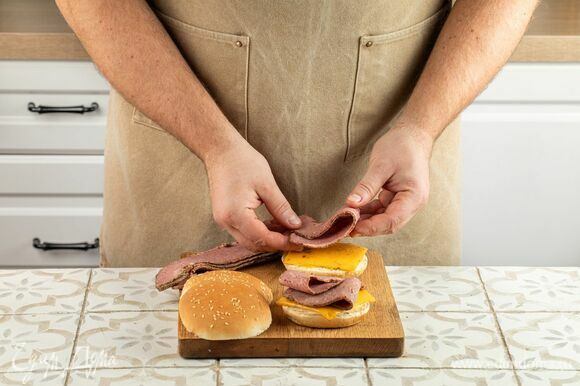 На булочку, которая будет служить основой для бургера, выложите тонко нарезанную пастрами. Можно взять говяжью или пастрами из индейки.