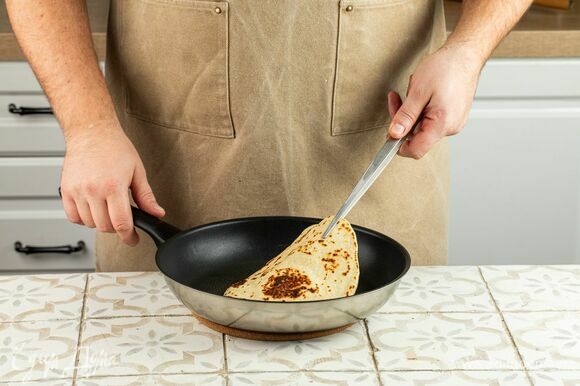 Разогрейте в сковороде с толстыми стенками масло — оно должно полностью покрывать дно. Положите лепешку и, вращая сковородку по кругу, обжарьте лепешку до румяной корочки. Переверните и обжарьте с другой стороны.