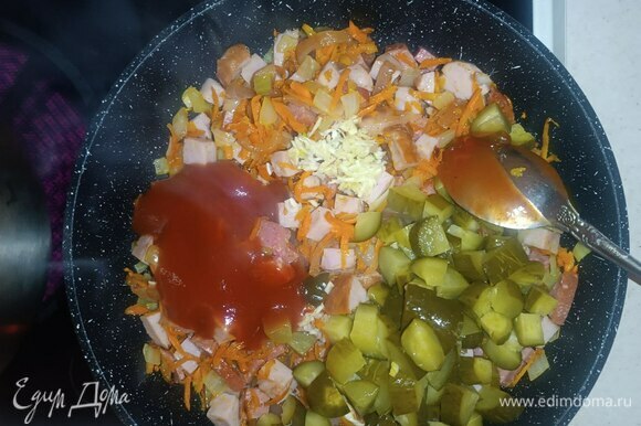 После добавляем огурцы, томатную пасту и три ложки огуречного рассола, тушим около трех минут.