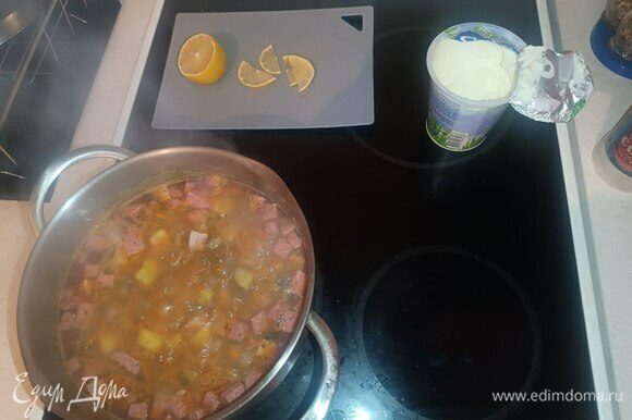 В суп добавляем маслины, специи, укроп. Накрываем крышкой, убавляем огонь и варим минут 5. А пока подготавливаем оставшееся. Лимон нарезаем тонкими полукругами.