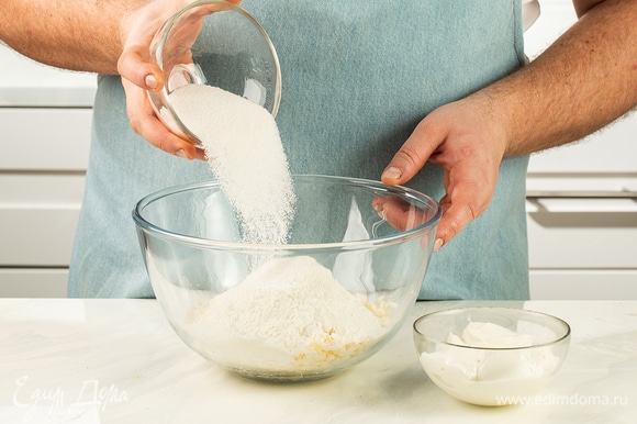 Просейте муку к маргарину. Туда же положите сметану, сахар и разрыхлитель, щепотку соли.