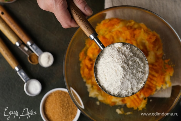 Всыпьте пшеничную муку, сахар, разрыхлитель, ванильный сахар, соль и корицу. С помощью лопатки замешайте мягкое тесто.