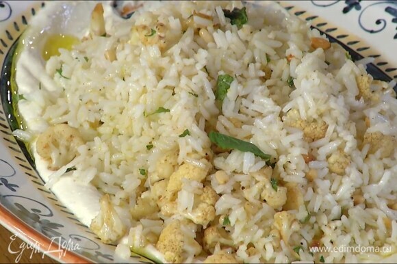 Рис перемешать с цветной капустой, кедровыми орехами и мятой, выложить все на тарелку с йогуртом, полить оставшимся оливковым маслом и украсить отложенными листьями мяты.