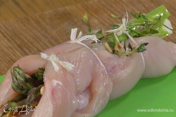 Куриное филе надрезать сбоку, не прорезая до конца, затем раскрыть, слегка отбить скалкой, посолить и поперчить. Выложить на одну половину каждой грудки несколько стеблей спаржи, кедровые орехи и по паре веточек тимьяна, сбрызнуть оливковым маслом, накрыть второй половиной грудки и обвязать кулинарной нитью.