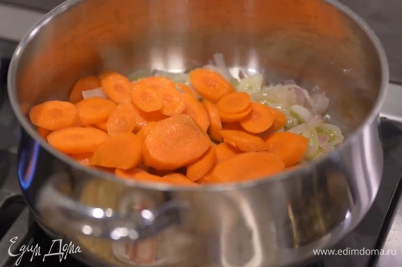 Морковь почистить, нарезать кружками, выложить в кастрюлю и дать ей пропитаться ароматами овощей.