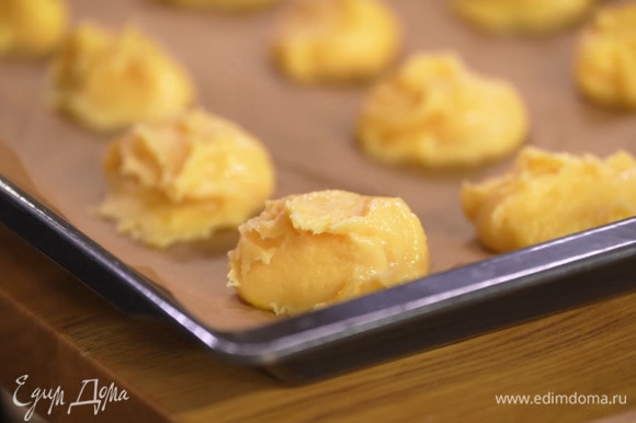На выстеленный бумагой для выпечки противень столовой ложкой выложить небольшие шарики теста.