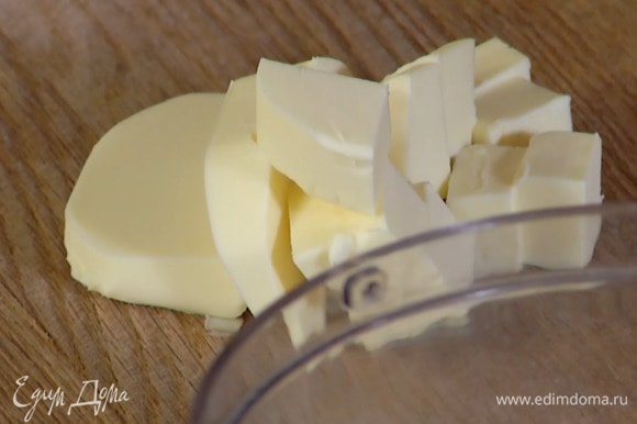 Предварительно охлажденное сливочное масло нарезать кубиками.